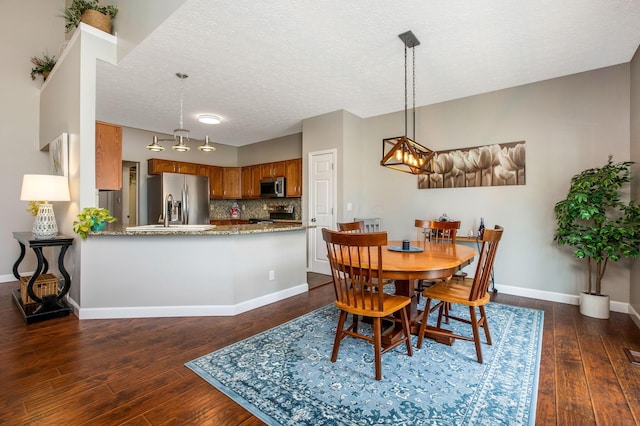 247 Trail E, Pataskala, OH 43062 - dining room with dark wood-style floors, a textured ceiling, and a chandelier