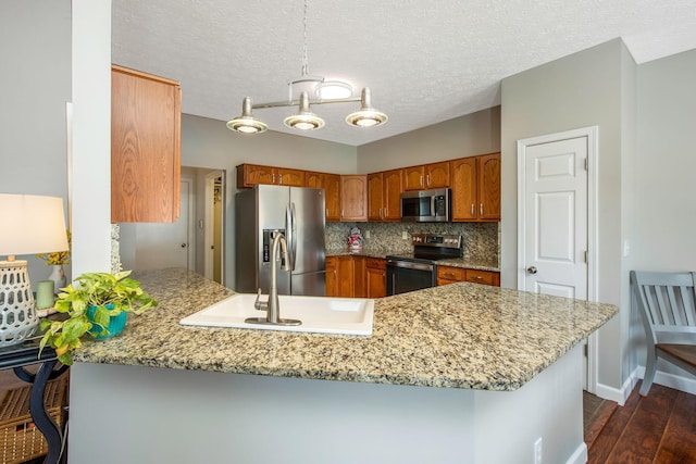247 Trail E, Pataskala, OH 43062 - kitchen with appliances with stainless steel finishes, a peninsula, brown cabinets, dark wood-style floors, and backsplash