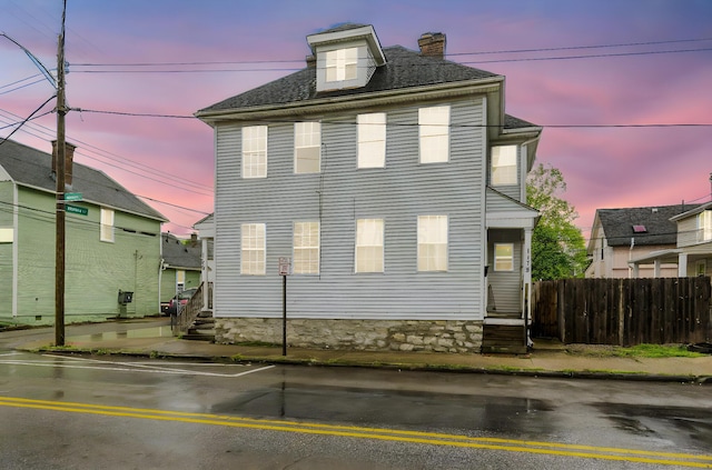 rear view of property featuring fence and a chimney