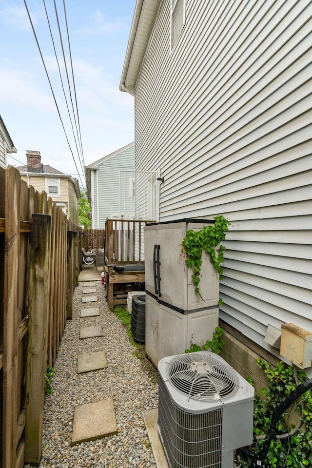 view of side of home featuring central AC unit and fence