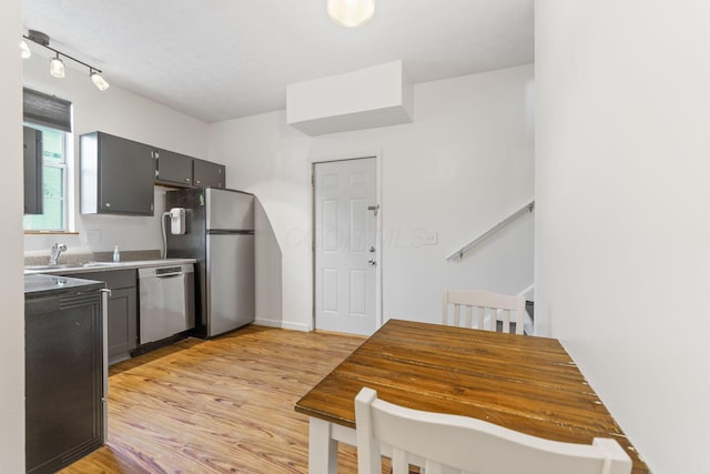 kitchen with stainless steel appliances, light wood-style floors, a sink, and gray cabinets