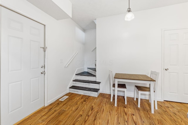 entrance foyer with stairway, light wood-style floors, and baseboards