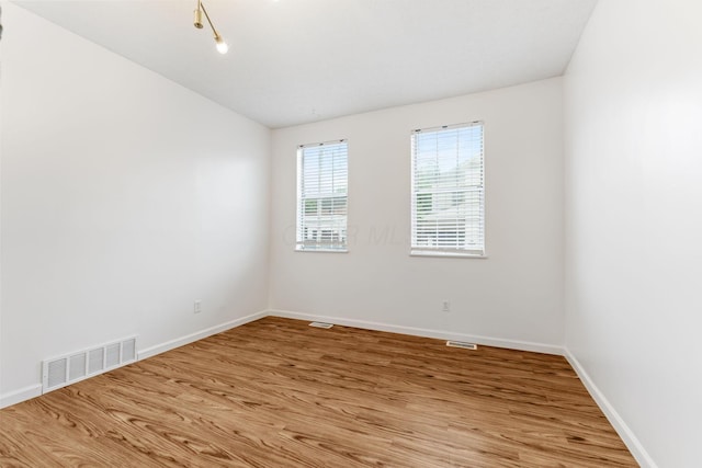 empty room featuring light wood-type flooring and baseboards