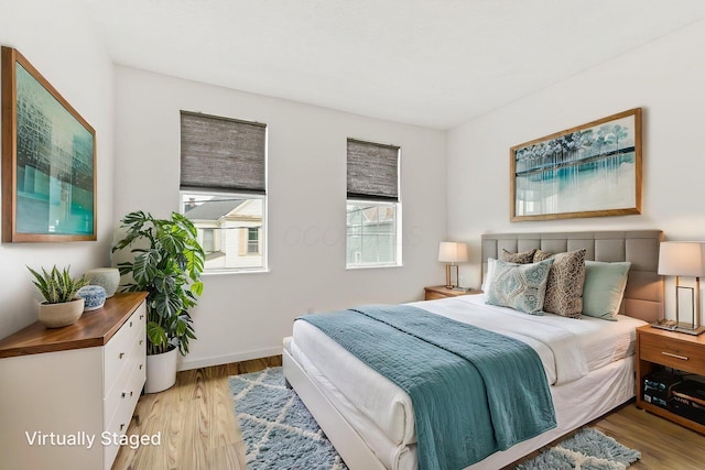 bedroom with light wood-type flooring and baseboards