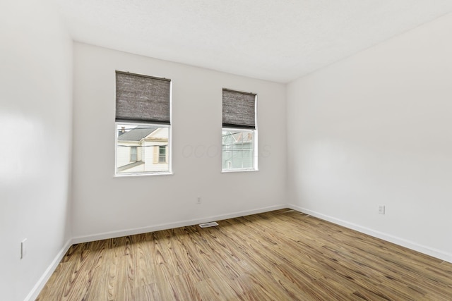 spare room featuring wood finished floors and baseboards