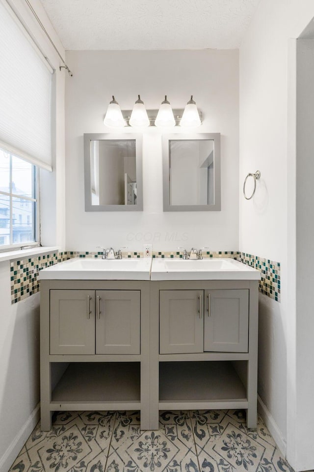 bathroom featuring double vanity, tile patterned floors, and baseboards