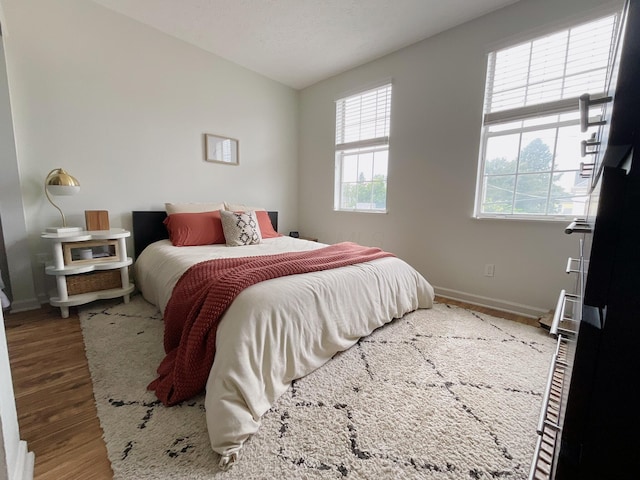 bedroom with wood finished floors and baseboards