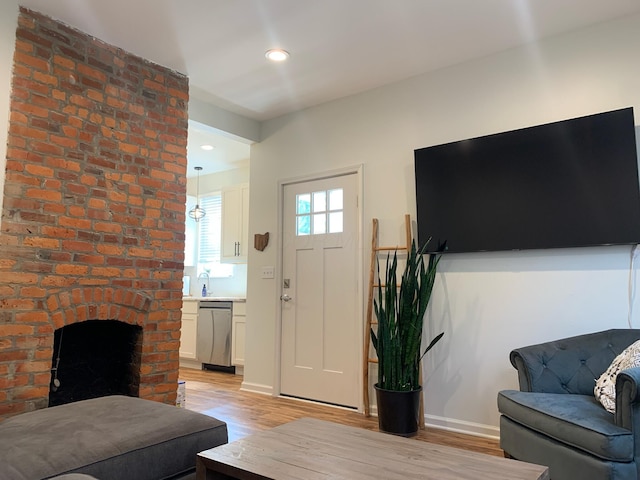 living area with light wood-type flooring, a fireplace, and recessed lighting