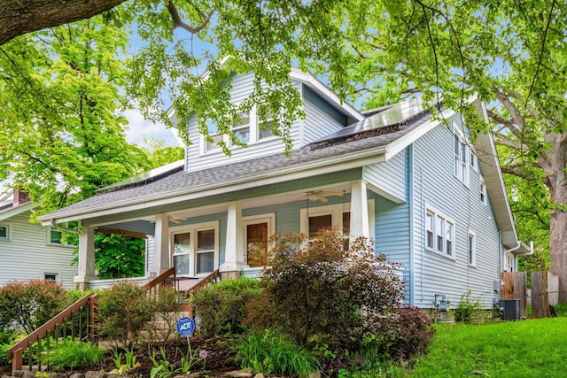 view of front of house featuring a ceiling fan, a porch, fence, and roof mounted solar panels