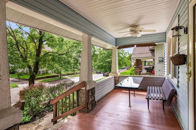 wooden terrace featuring covered porch and a ceiling fan