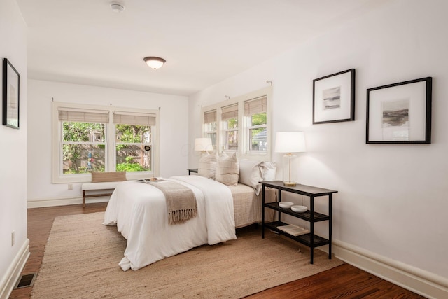 bedroom with wood finished floors and baseboards