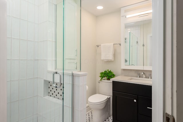 bathroom with a shower stall, toilet, vanity, and tile patterned floors