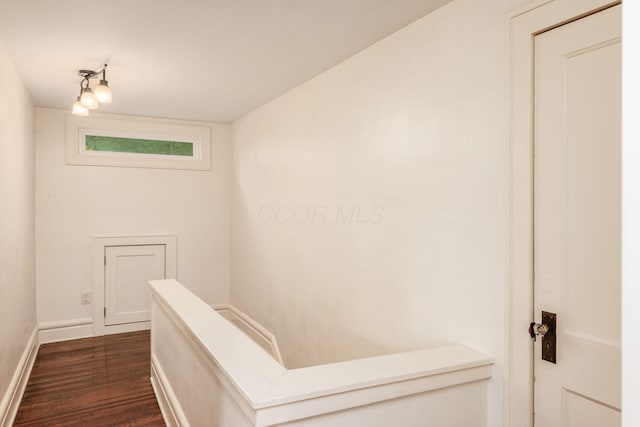 staircase featuring wood finished floors and baseboards