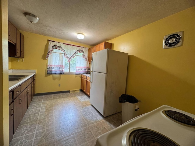 3457 Petzinger Rd, Columbus, OH 43232 - kitchen with white appliances, light countertops, a textured ceiling, baseboards, and light floors