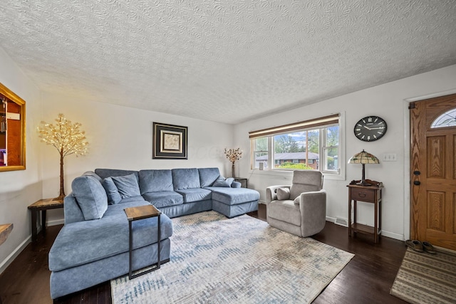 living area with wood finished floors, a textured ceiling, and baseboards