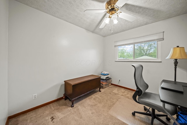 carpeted home office featuring baseboards, a textured ceiling, and a ceiling fan