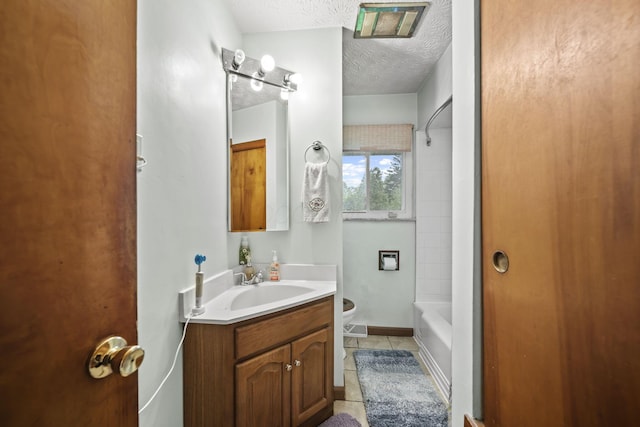 full bathroom with toilet, tile patterned floors, a textured ceiling, vanity, and tub / shower combination