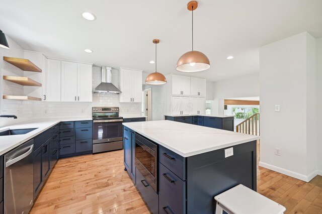 500 Cherrington Ct, Westerville, OH 43081 - kitchen featuring stainless steel appliances, wall chimney range hood, a sink, a center island, and light wood-type flooring