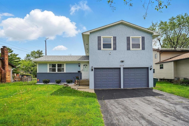 5508 Aspen Rd, Columbus, OH 43229 - tri-level home with an attached garage, a front lawn, driveway, and stucco siding