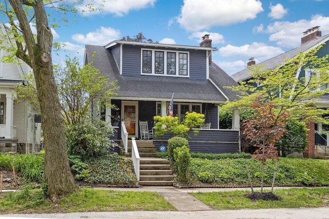 bungalow-style home featuring covered porch, roof with shingles, and a chimney