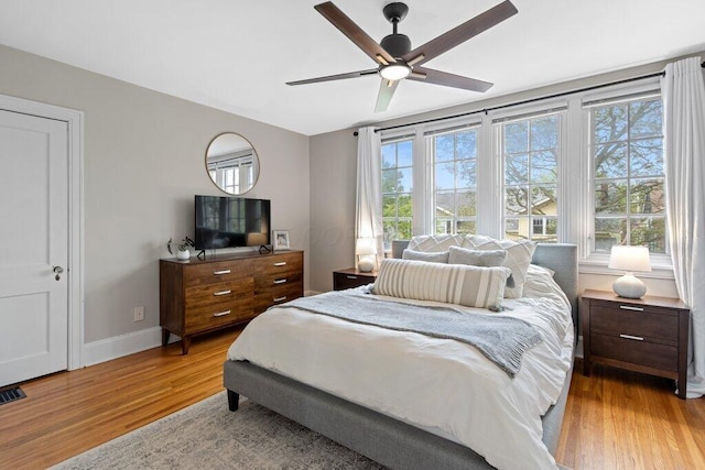 bedroom with wood finished floors, baseboards, and a ceiling fan