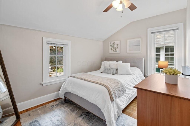 bedroom featuring vaulted ceiling, wood finished floors, baseboards, and a ceiling fan