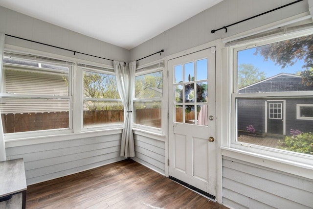 entryway with wood finished floors, healthy amount of natural light, and wood walls