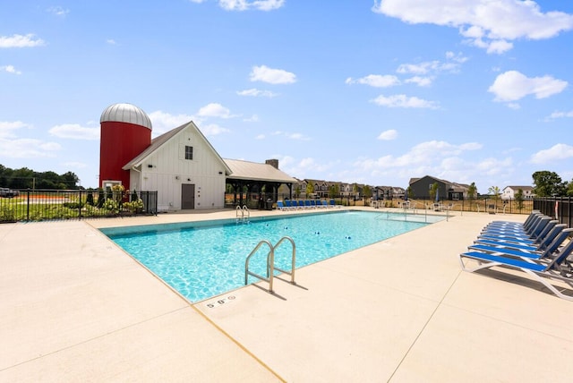 community pool featuring fence and a patio area