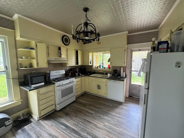 kitchen featuring white appliances, an ornate ceiling, a sink, dark countertops, and a chandelier