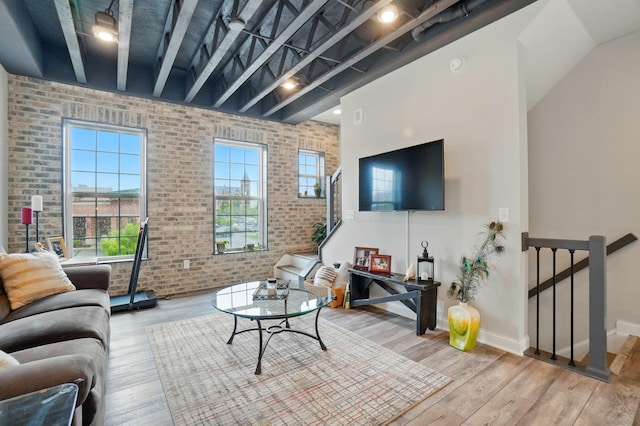 20 N Center St Unit 20, Springfield, OH 45502 - living area featuring brick wall, wood finished floors, baseboards, and a towering ceiling
