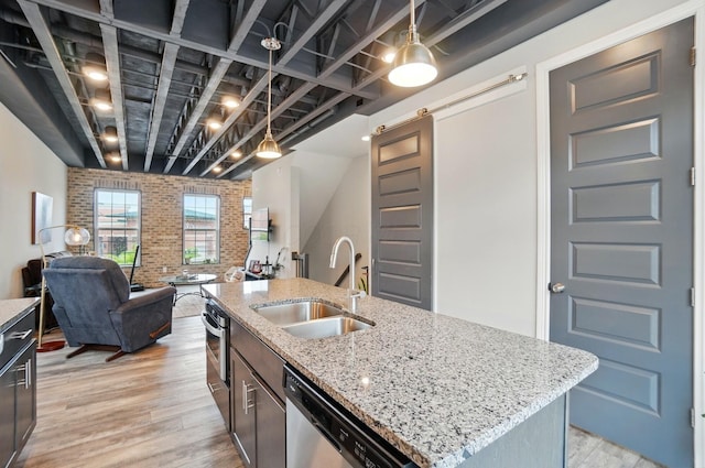 20 N Center St Unit 20, Springfield, OH 45502 - kitchen with a sink, a barn door, appliances with stainless steel finishes, brick wall, and open floor plan