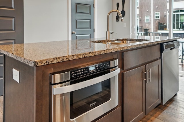 20 N Center St Unit 20, Springfield, OH 45502 - kitchen featuring a sink, stainless steel appliances, light stone countertops, light wood-style floors, and dark brown cabinetry