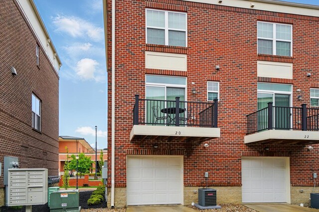20 N Center St Unit 20, Springfield, OH 45502 - view of front of home with brick siding, a garage, central AC unit, and driveway