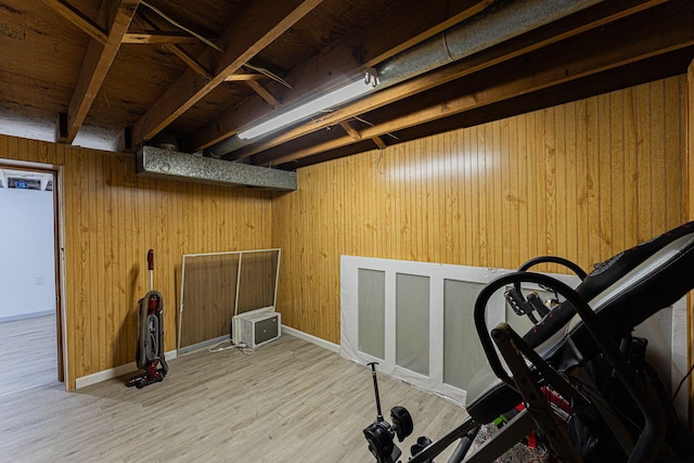 workout area with wood finished floors, wood walls, and baseboards