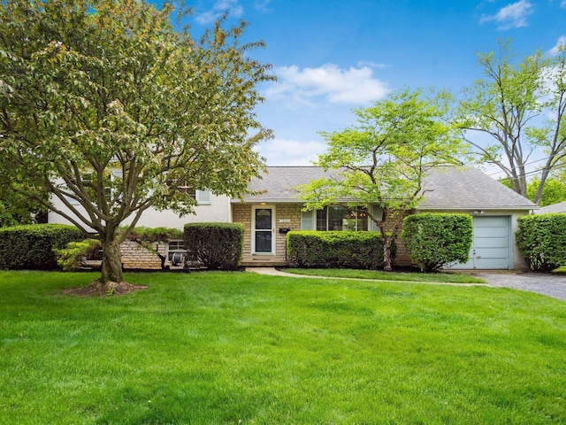 ranch-style house featuring a front yard, a garage, asphalt driveway, and roof with shingles