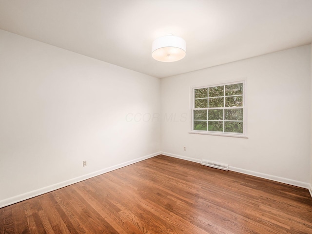 empty room with wood finished floors and baseboards
