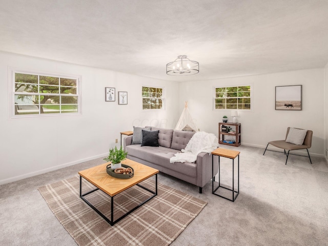 carpeted living room featuring a chandelier, healthy amount of natural light, and baseboards