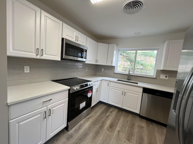 3019 Brownlee Ave, Columbus, OH 43209 - kitchen featuring stainless steel appliances, a sink, white cabinetry, and wood finished floors