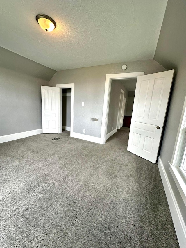 375 N Main St, Marion, OH 43302 - unfurnished bedroom with vaulted ceiling, baseboards, dark colored carpet, a textured ceiling, and a closet
