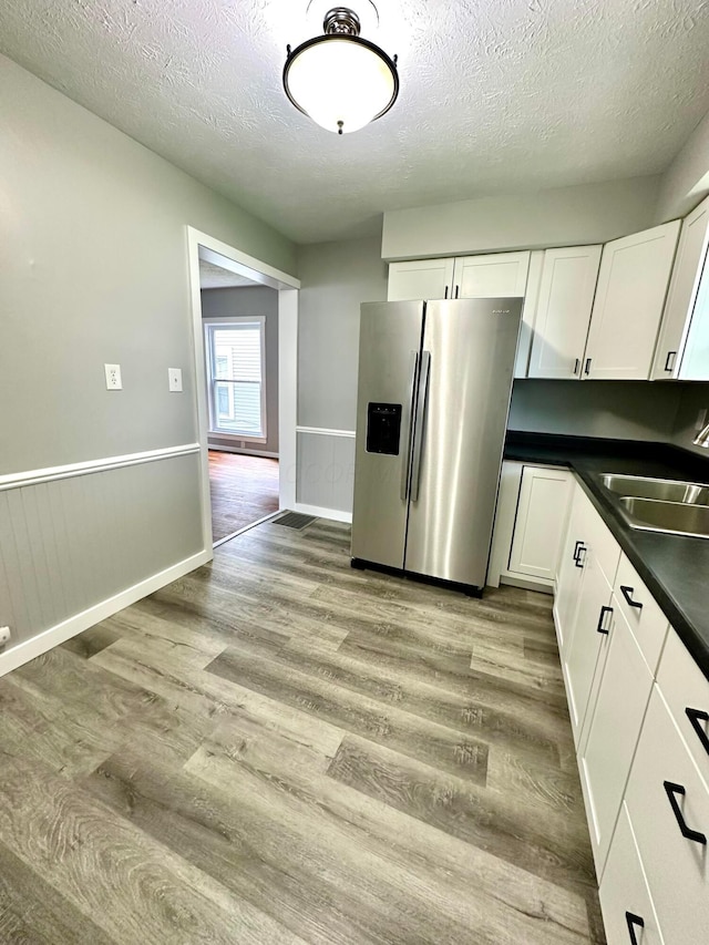 375 N Main St, Marion, OH 43302 - kitchen with stainless steel refrigerator with ice dispenser, a sink, a textured ceiling, light wood-type flooring, and dark countertops