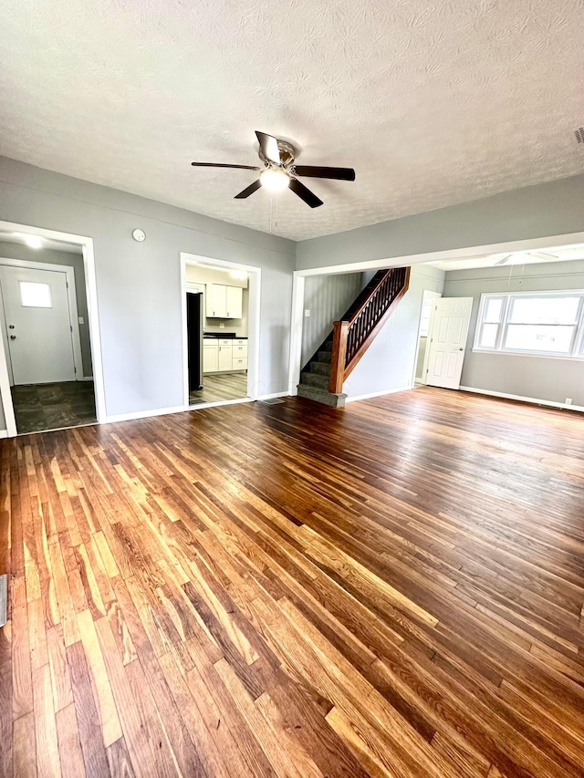 375 N Main St, Marion, OH 43302 - unfurnished living room featuring ceiling fan, hardwood / wood-style flooring, stairway, a textured ceiling, and baseboards