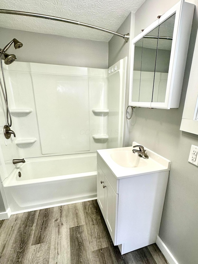 375 N Main St, Marion, OH 43302 - bathroom with wood finished floors, shower / tub combination, vanity, a textured ceiling, and baseboards