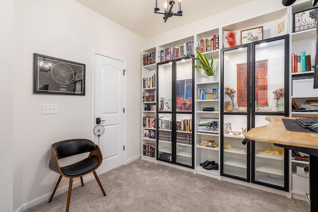 interior space featuring carpet floors, baseboards, and a chandelier