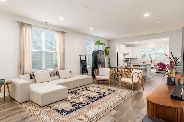living area featuring light wood-type flooring, healthy amount of natural light, and recessed lighting