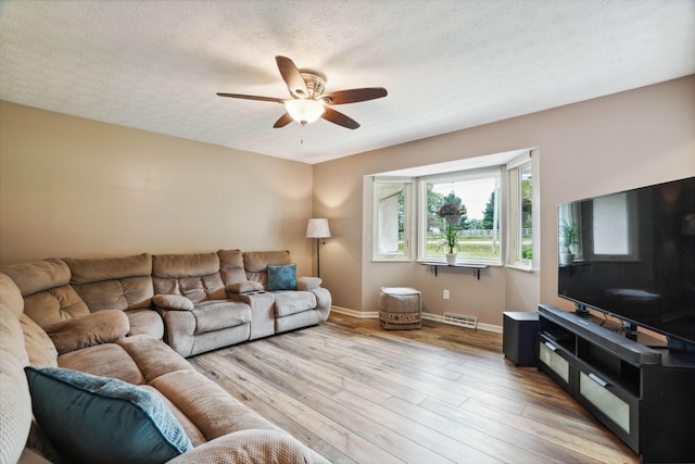 10842 Johnstown Rd, New Albany, OH 43054 - living area with a ceiling fan, baseboards, light wood-style flooring, and a textured ceiling