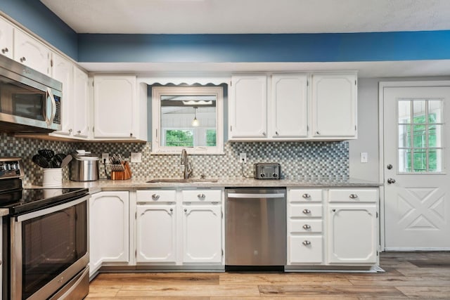 10842 Johnstown Rd, New Albany, OH 43054 - kitchen with stainless steel appliances, a sink, white cabinetry, and decorative backsplash