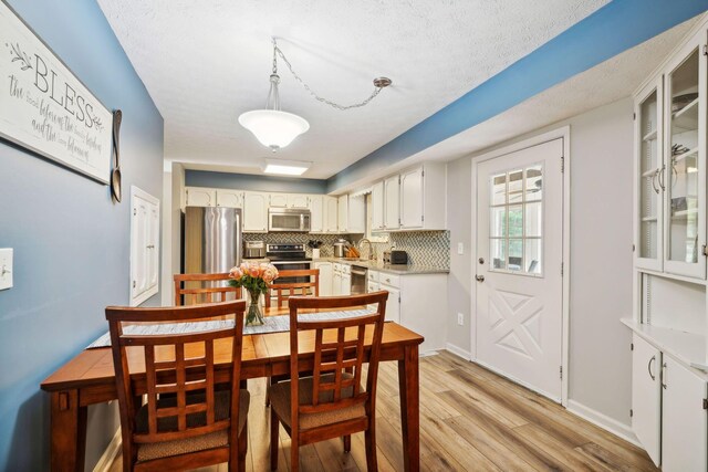 10842 Johnstown Rd, New Albany, OH 43054 - dining room featuring light wood-style floors and a textured ceiling