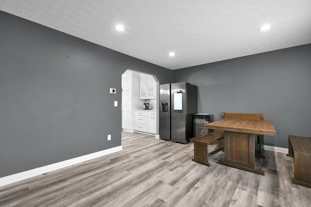 10129 Granden St, Pickerington, OH 43147 - kitchen featuring stainless steel fridge with ice dispenser, white cabinets, baseboards, light wood-style flooring, and a textured ceiling