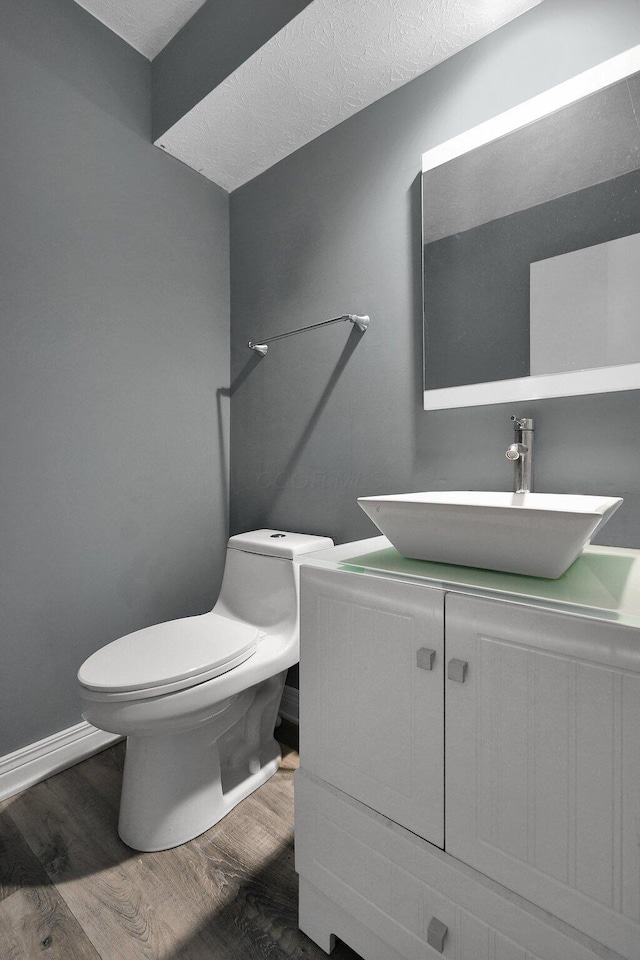 10129 Granden St, Pickerington, OH 43147 - bathroom with toilet, wood finished floors, vanity, a textured ceiling, and baseboards