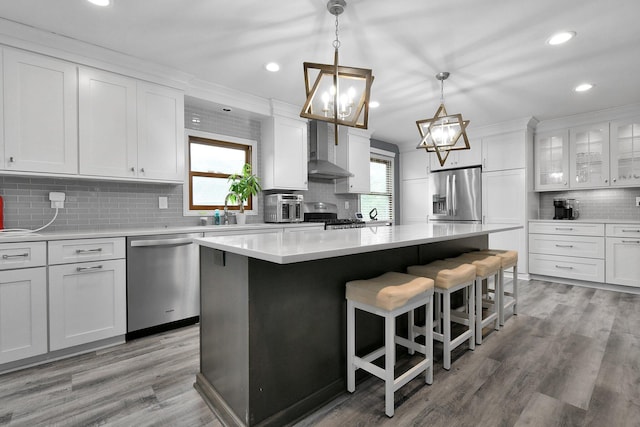 10129 Granden St, Pickerington, OH 43147 - kitchen with appliances with stainless steel finishes, wall chimney range hood, tasteful backsplash, a kitchen island, and white cabinets